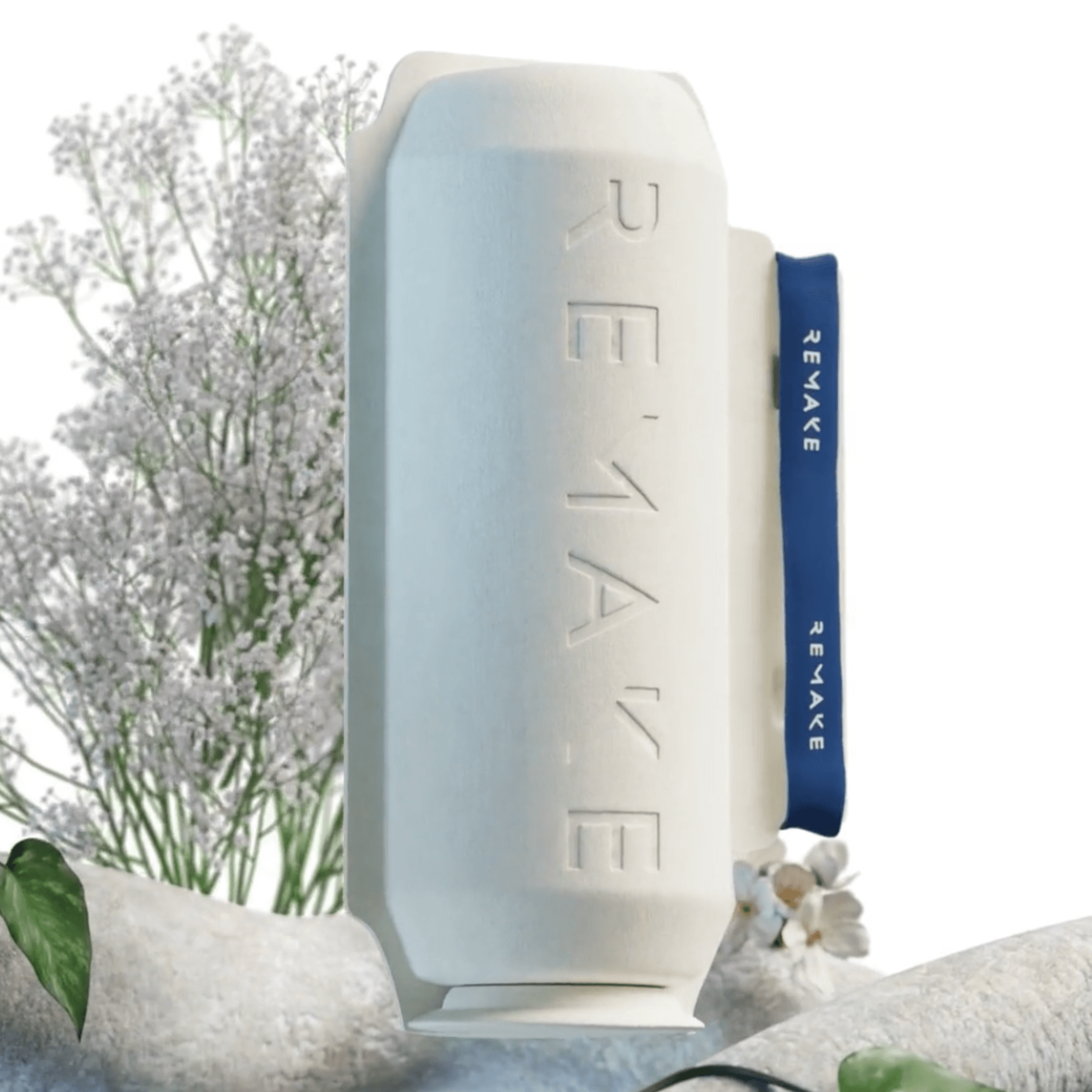 Eco friendly biodegradable REMAKE box surrounded by flowers, natural skincare and circular beauty